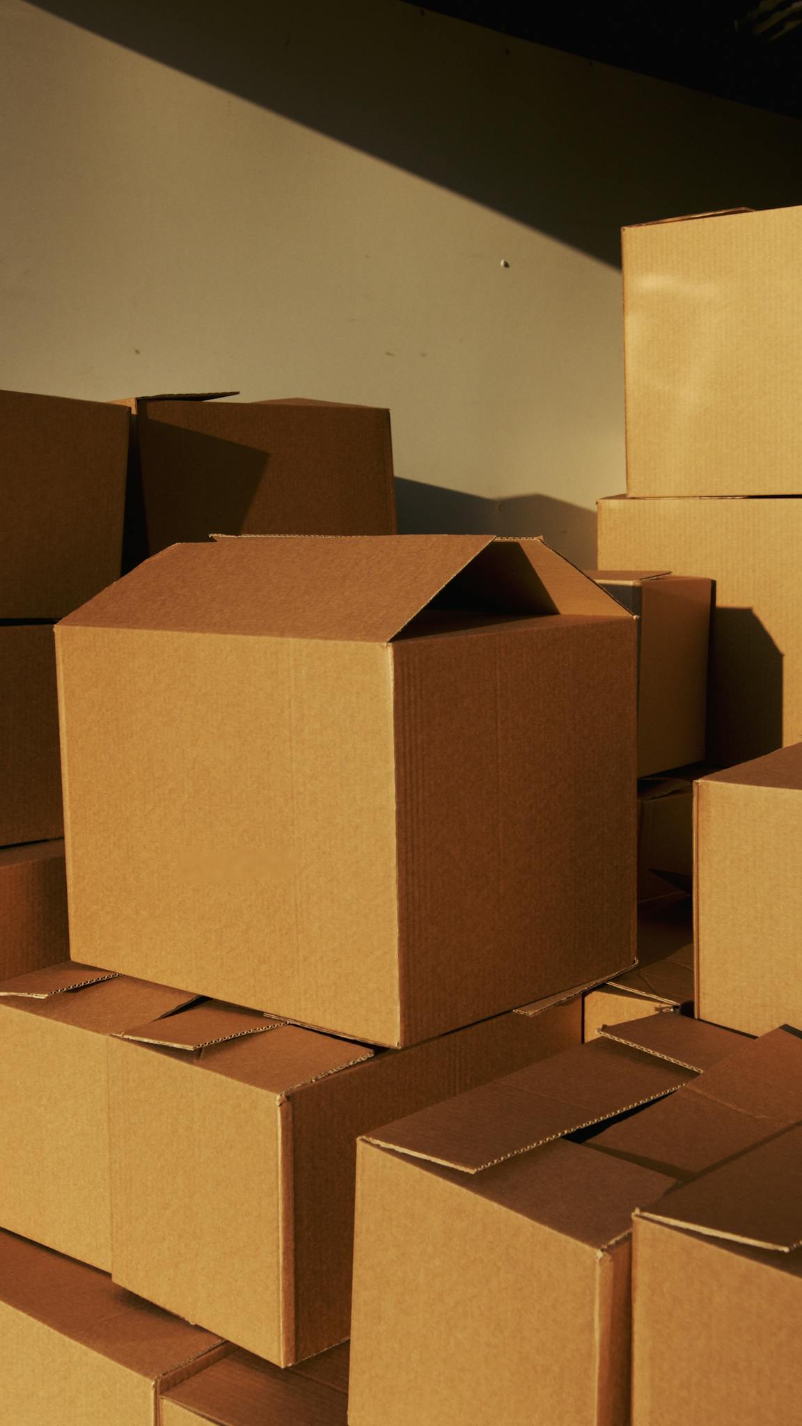 Stacked cardboard boxes ready for shipping or storage in a warehouse setting.